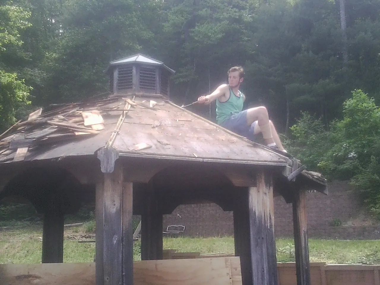 Tearing the old roof off a wooden gazebo before new shakes in North Manchester