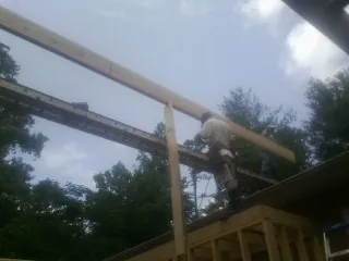 Carpenter setting a ridge beam over a new addition frame — Ice Dam Removal by Roofing Brothers in North Manchester