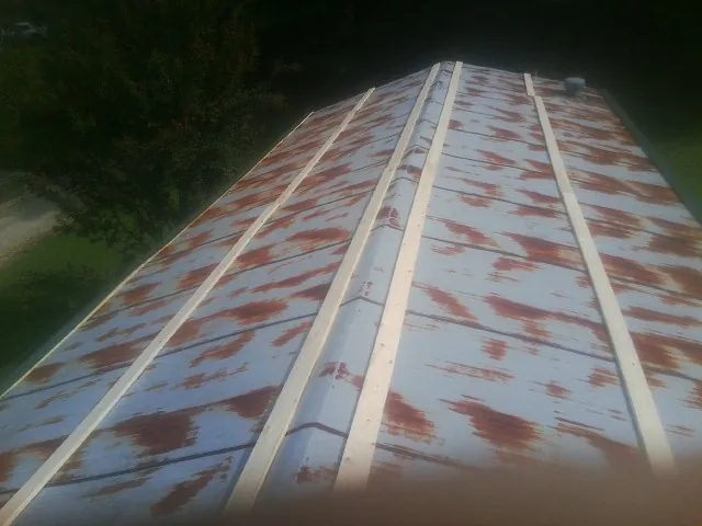 Rusted metal roof panels with new wood purlins before replacement — Storm Damage Roof Repair in North Manchester by Roofing Brothers
