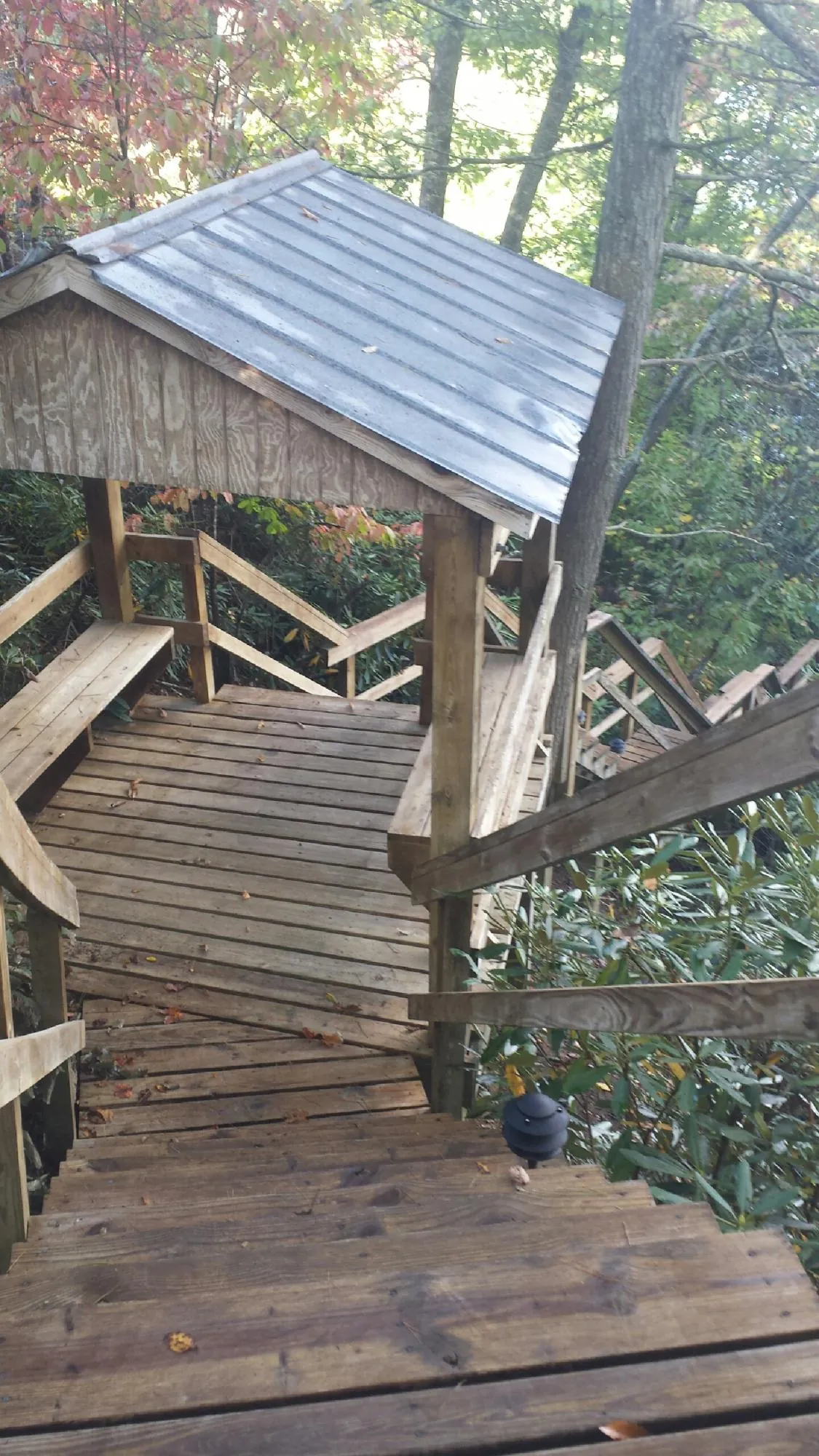 Metal roofed shelter over wooden steps on a wooded walkway — Skylight Repair & Installation work by our crew in North Manchester