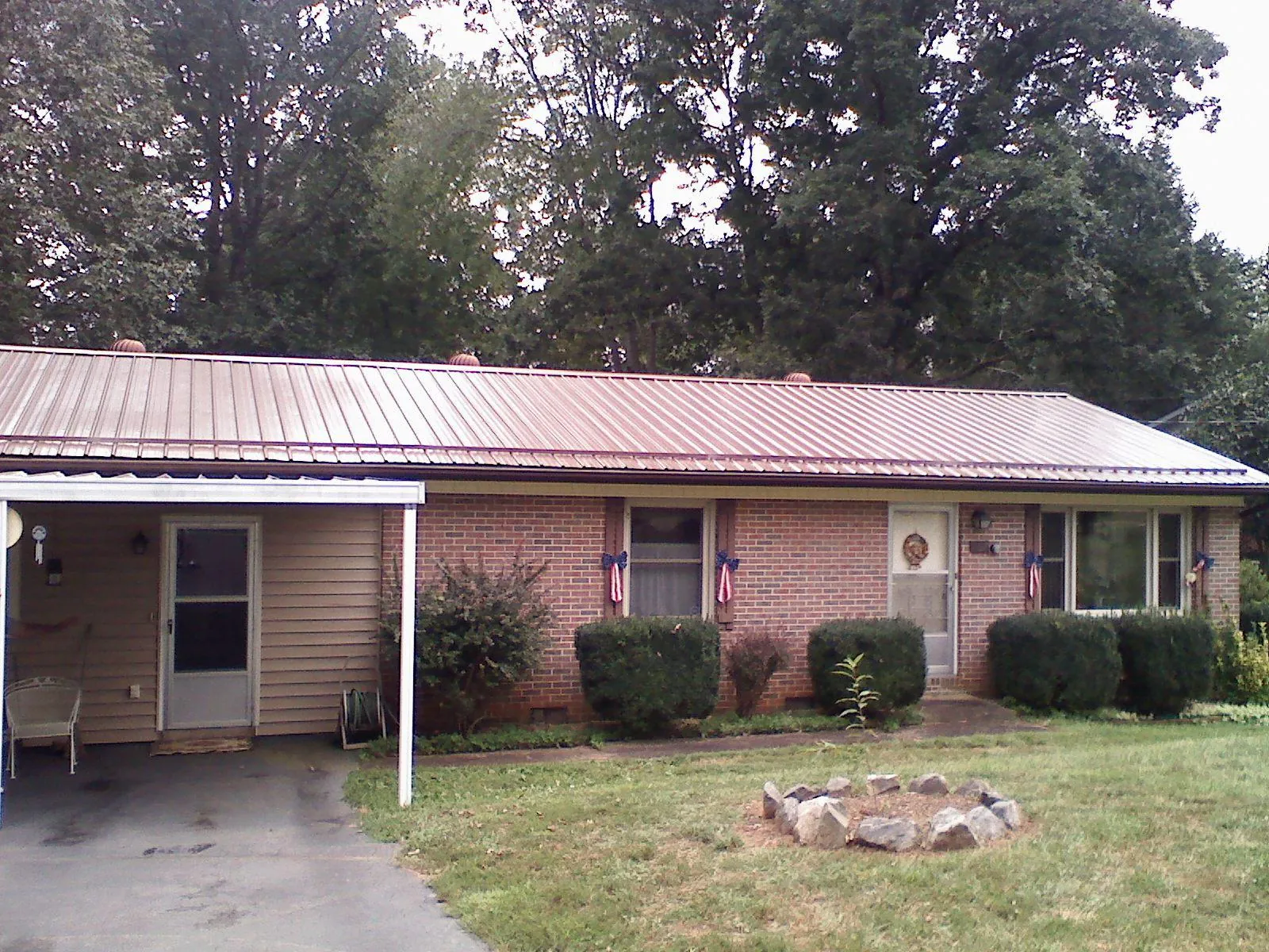 Bronze metal roof and carport on a brick ranch home — Roof Repair work by our crew in North Manchester